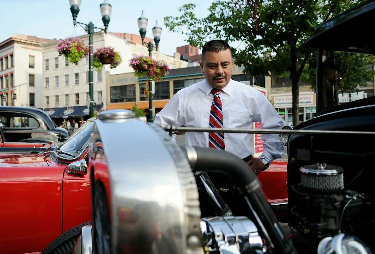 Alexandro Tehuidzi, White Plains, checks out an antique Ford on display. Several hundred people gathered in Columbus Park in Stamford on Wednesday evening, July 28, 2010 for the Pops in the Park concert, featuring Bowser's Rock 'n' Roll Party, along with an assembly of more than 50 antique cars, most from the fifties and sixties.