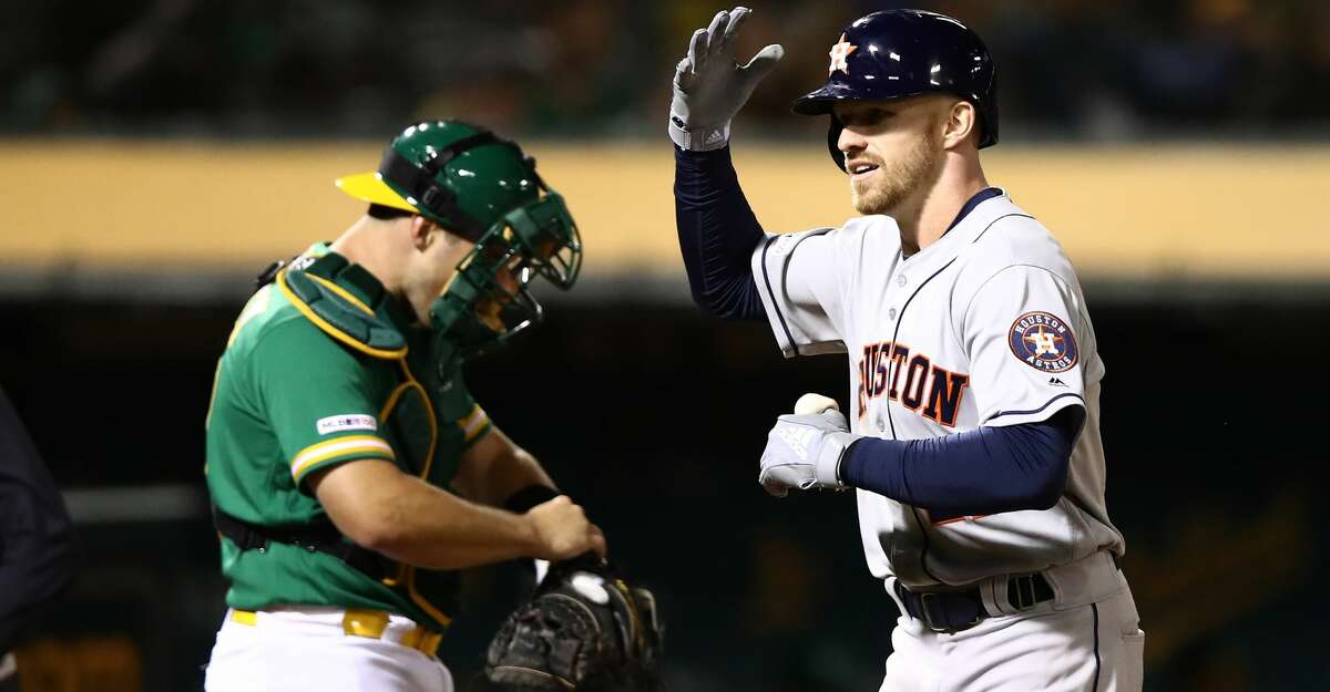 OAKLAND, CALIFORNIA - MAY 31: Derek Fisher #21 of the Houston Astros reacts as he runs past Josh Phegley #19 of the Oakland Athletics after he hit a home run in the eighth inning at Oakland-Alameda County Coliseum on May 31, 2019 in Oakland, California. (Photo by Ezra Shaw/Getty Images)