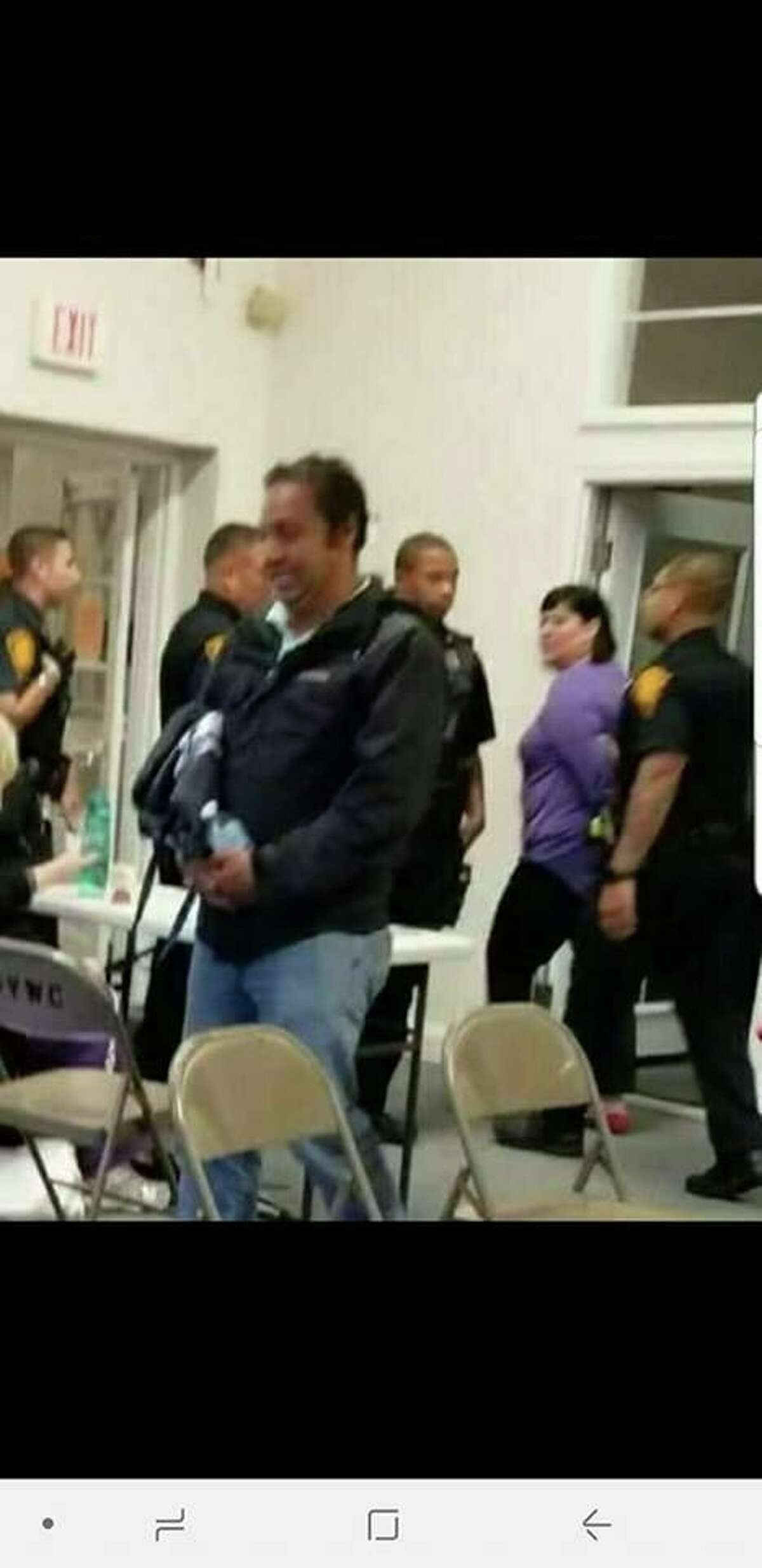 This is a blurry cellphone photo showing Bridgeport School Board member Maria Pereira being led away by police at a meeting of Success Village residents Tuesday night, Sept. 11, 2018