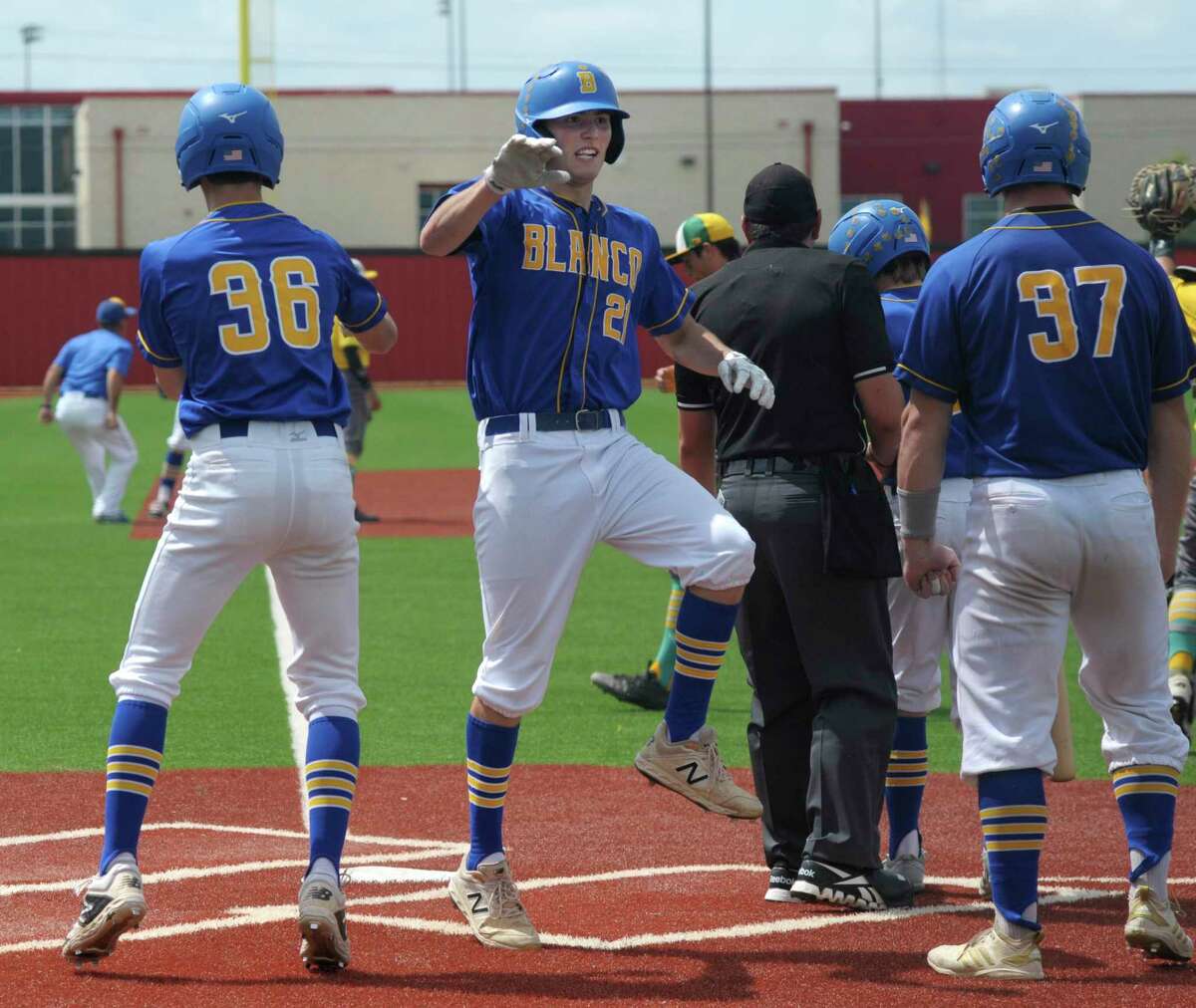 Blanco's Justin Wardlow (21) celebrates with teammates after scoring on a 7th-inning three-RBI triple by teammate Baylor Smith during Game 2 of the 3A regional final playoff series against Bishop in Jourdanton on Saturday, June 1, 2019. Blanco won and advances to the state tournament.