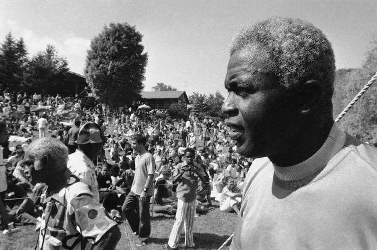 Former Baseball great Jackie Robinson, right, looks over some 2,000 people assembled on the lawn of his home at Stamford, Connecticut on Sunday, June 27, 1971 before the opening of a Jazz Concert to benefit Daytop Inc., a drug rehabilitation center. The concert was organized by the ex-baseball star's son, Jackie Jr., a former addict and official at the drug rehabilitation center, who died in an auto accident.