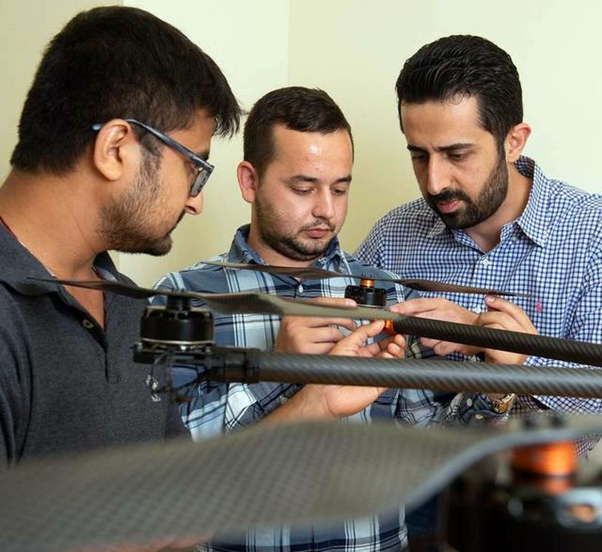 SIUE School of Engineering’s Nima Lotfi, PhD, (back) and his students Nedret Ramic (middle), a mechanical engineering graduate student, and Pratik Lamsal, a senior mechanical engineering major, assemble a large drone. Lotfi is the faculty advisor for the Drone Club of SIUE.