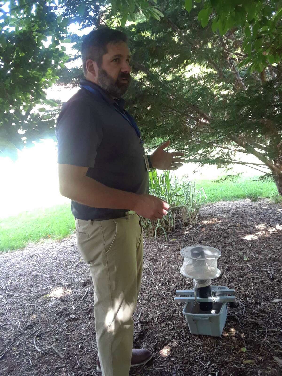 John Shepard of the Connecticut Agricultural Experiment Station in New Haven demonstrates how to hang a mosquito trap at the station on June 3, 2019.