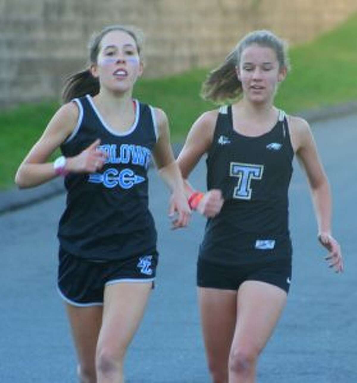 Fairfield Ludlowe’s Sarah Leatherwood and Trumbull High’s Kate Romanchick run side by side in Monday’s meet.