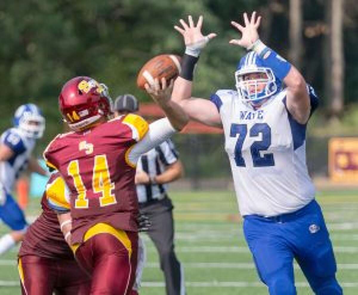 St. Joseph quarterback Cory Babineau throws through Darien's charging Andrew Stueber on Saturday. — David G. Whitham photo