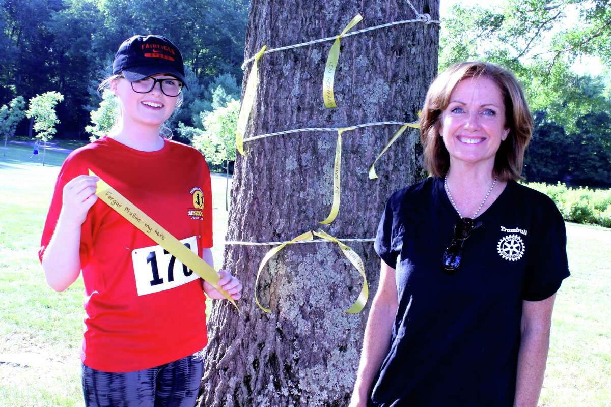 Club President Deborah Cox, right, with a young runner after last year's race.