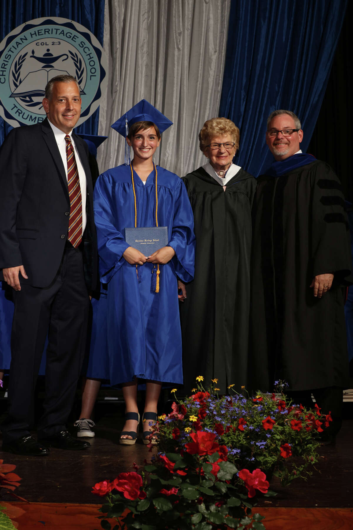 Christian Heritage School student Anais Anderson celebrates with school faculty at a graduation ceremony Saturday, June 11. Anderson, the great-granddaughter of the school’s founders Paul and June Anderson, is the 1,000th student to graduate from the Trumbull-based school.