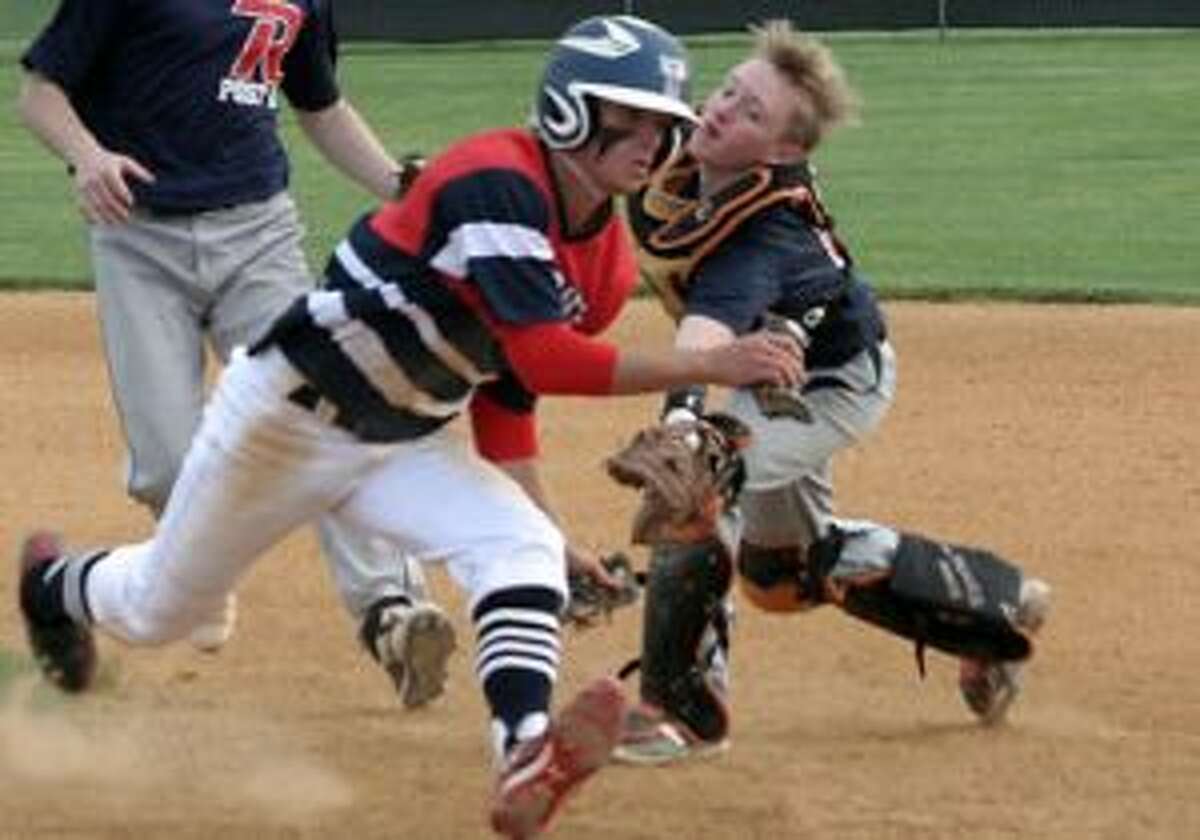 Post 141's Simon Whiteman avoided being tagged for three trips up and down the base path before getting past Ridgefield catcher Ryan Bogursky and being ruled safe. — Bill Bloxsom photo