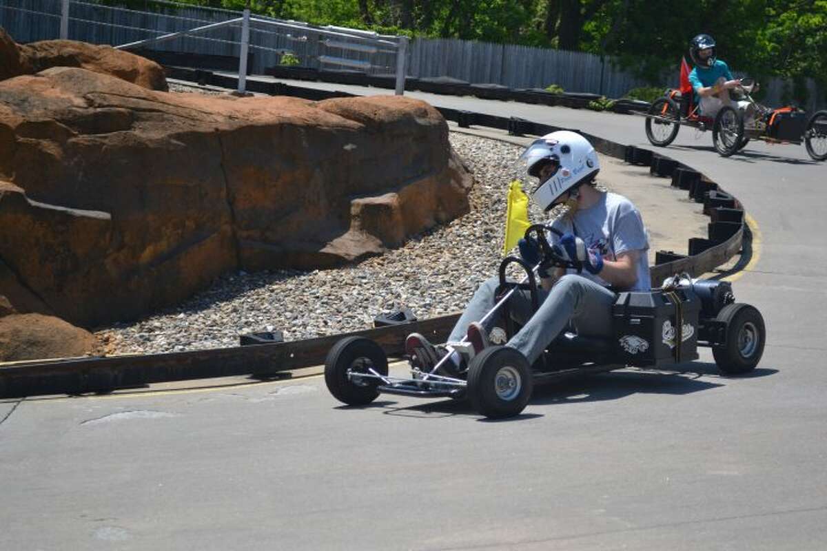 Trumbull High School senior Paul Buzel navigates the Berlin-based track inside the classroom-built electric car. Electric go-karts were driving by four Trumbull students last month in Berlin during an alternative energy competition that THS won.