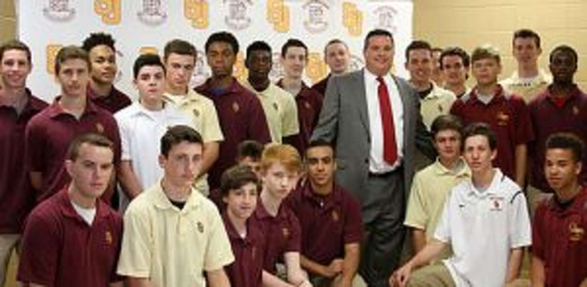 Paul Dudzinski is surrounded by members of the St. Joseph boys basketball team after Dudzinski was named coach of the Cadets.