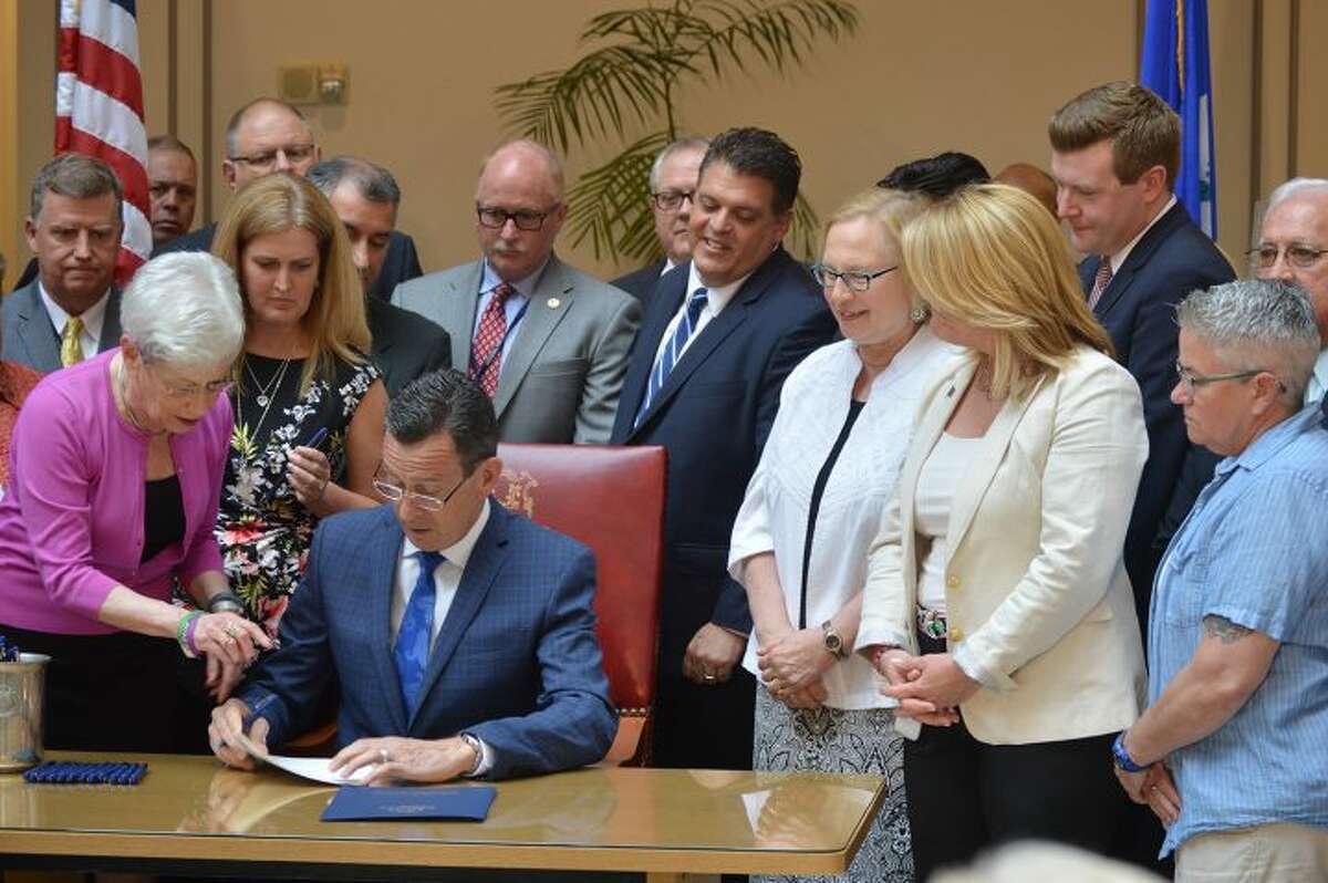 Gov. Dannel Malloy signs a bill that will expand the state's effort to combat the opioid epidemic Tuesday, May 31.