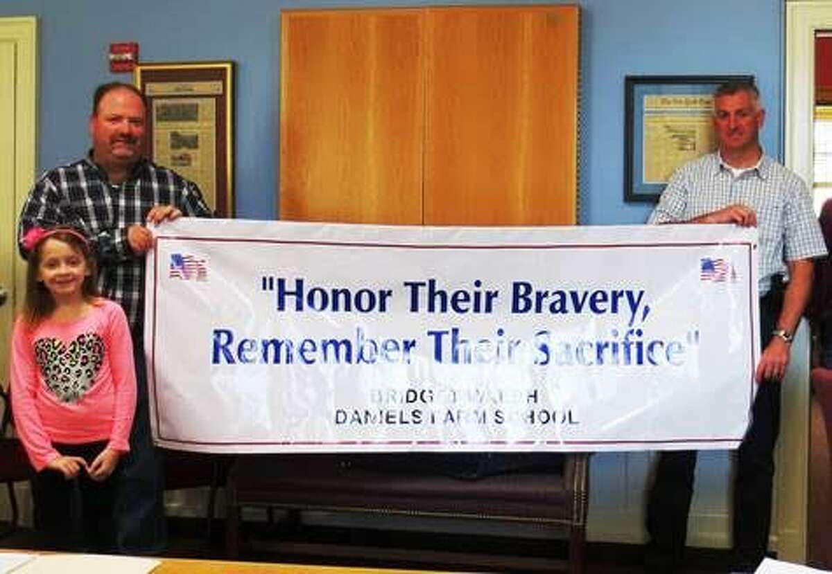 Daniels Farm Elementary School student Bridget Walsh came up with the theme “Honor their Bravery, Remember their Sacrifice” for this year’s Memorial Day Parade. She was congratulated by members of the Parade Committee last week.