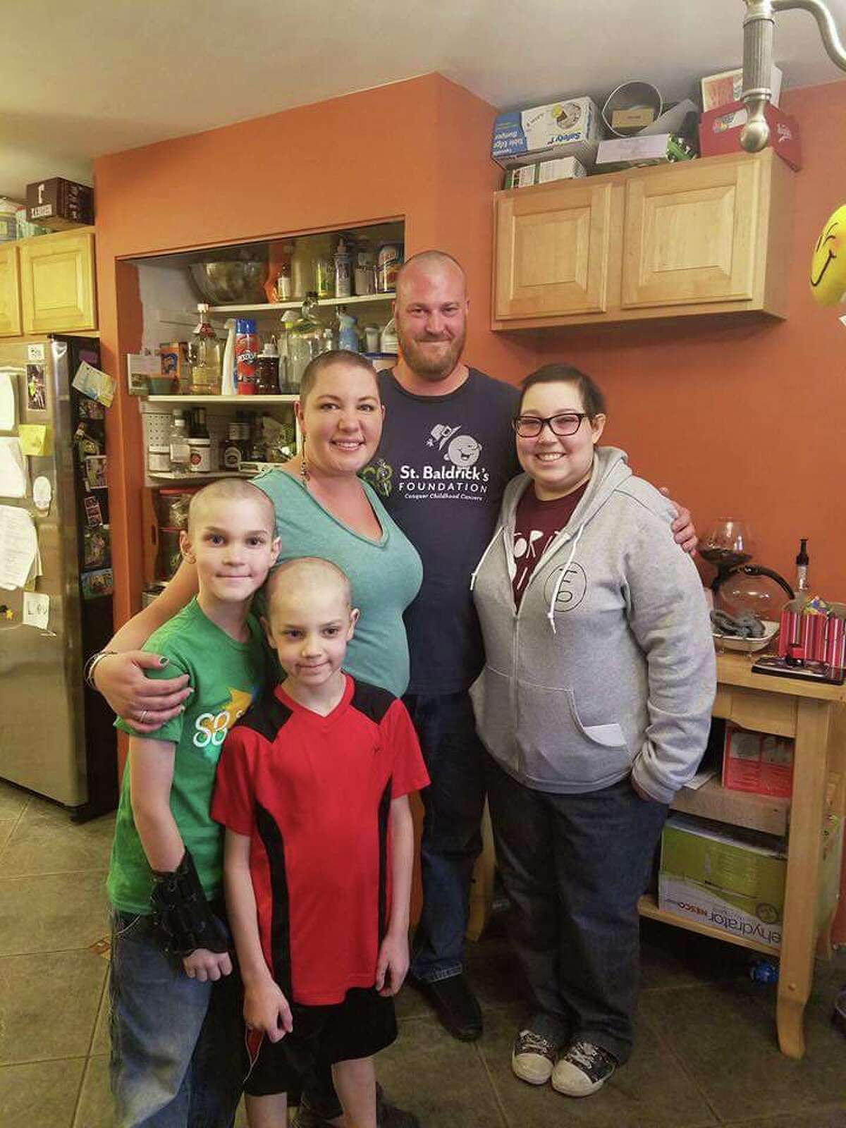 The entire Bulkley family poses — heads shaved — after Aubin met his mother's challenge.