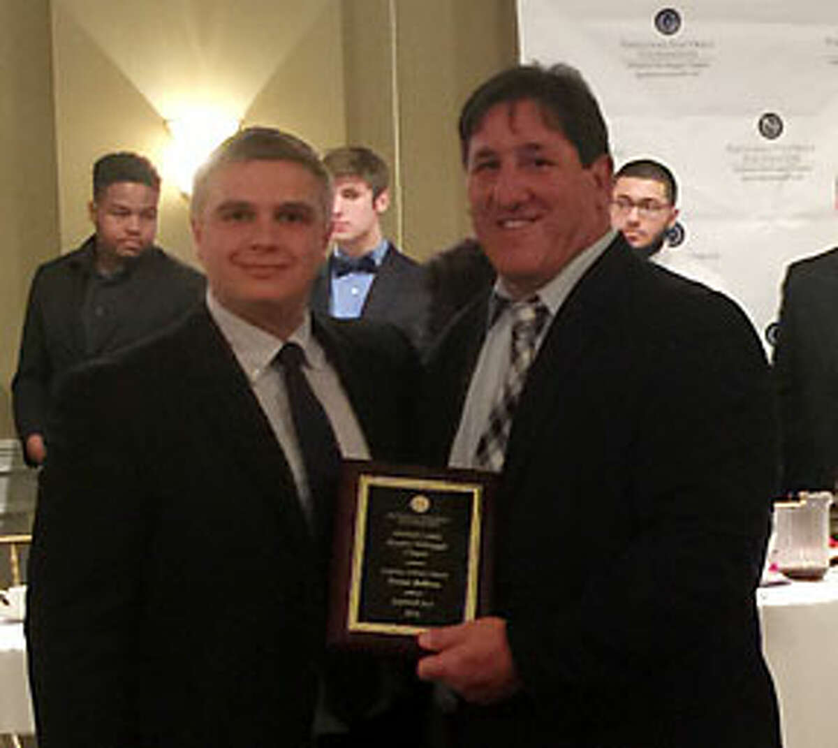 Trevor Bellows is presented with the National Football Foundation Scholar Athlete Award by John Barbarotta the Fairfield County Chapter president.