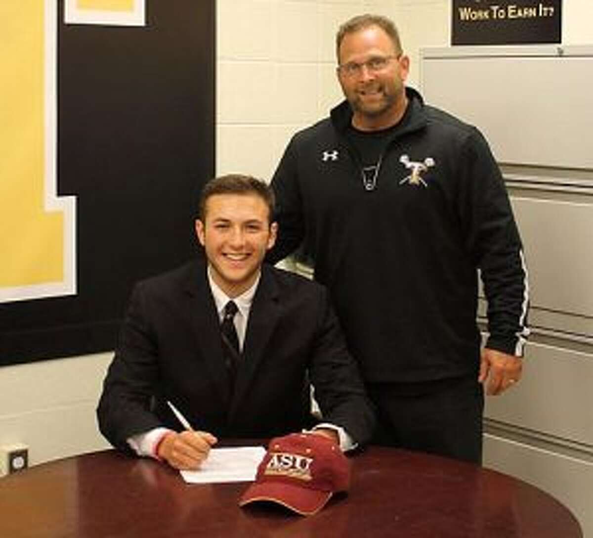 Trumbull High’s Michael DeVito, with Eagle coach Jim Kammerman looking on, signs his letter of intent to play collegiate men’s lacrosse at Arizona State University.