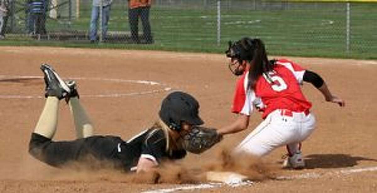 Trumbull High's Erica Fluskey slides safely into third base, as Greenwich's Julie Gambino makes the tag. - Bill Bloxsom photo