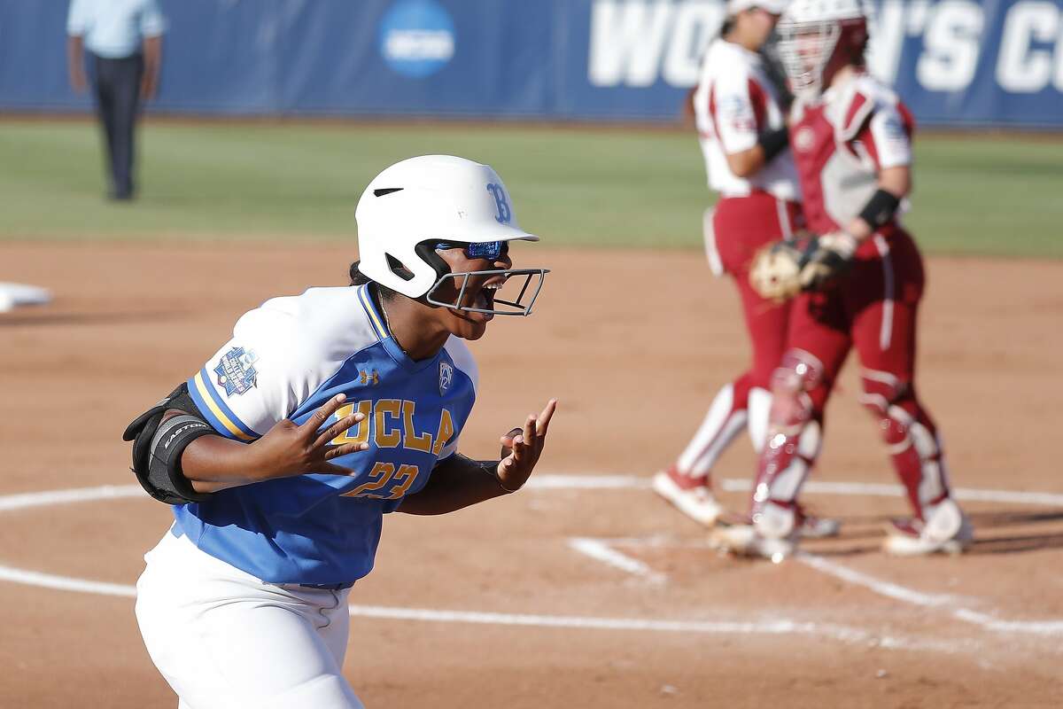 UCLA's Aaliyah Jordan gestures to her team as she runs in after hitting a home run against Oklahoma in the first inning of the first game of the best-of-three championship series in the NCAA softball Women's College World Series in Oklahoma City, Monday, June 3, 2019. (AP Photo/Alonzo Adams)