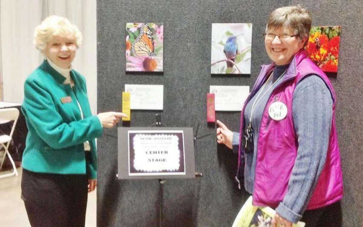Long Hill Garden Club members Nancy Lenoce and Cheryl Basztura display some of their award-winning photos.