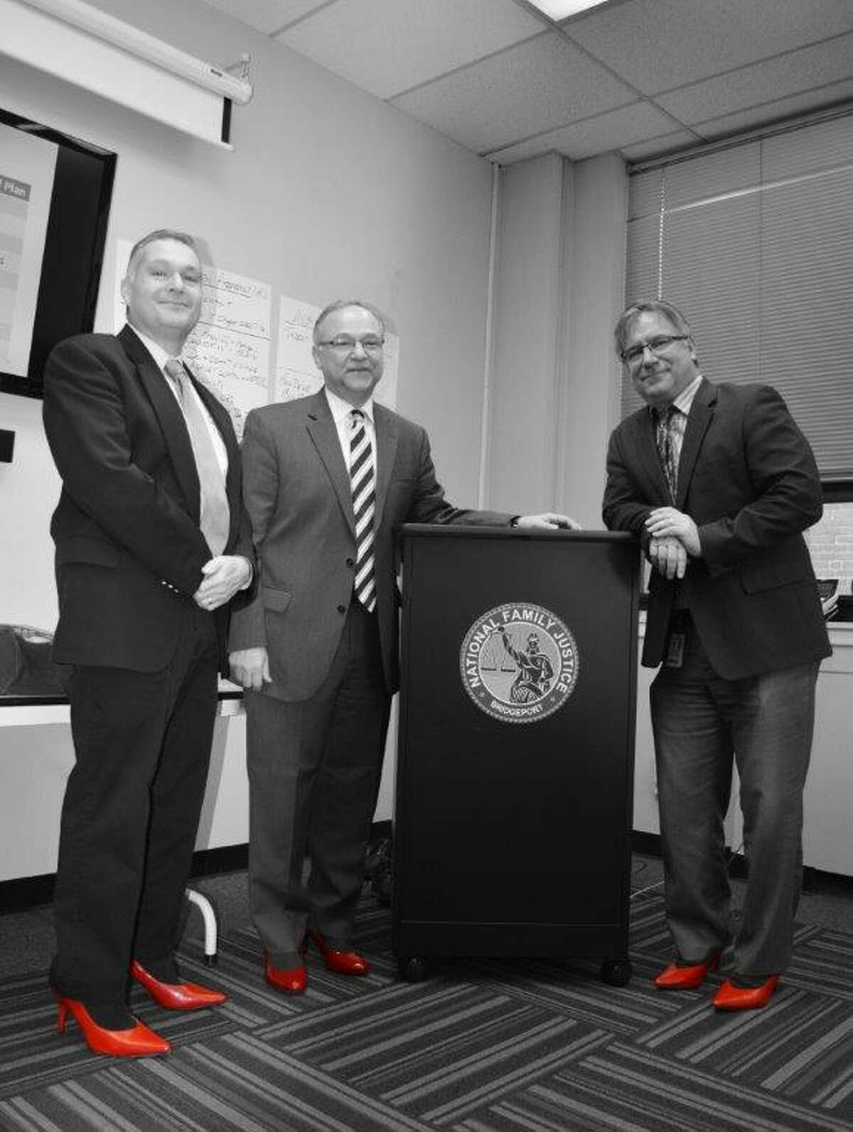 Trumbull Police Chief Michael Lombardo, Monroe Police Chief John Salvatore and Monroe First Selectman Steve Vavrek slip into a pair of red stilettos to support The Center of Family Justice’s Annual Walk a Mile in Her Shoes event on April 30.