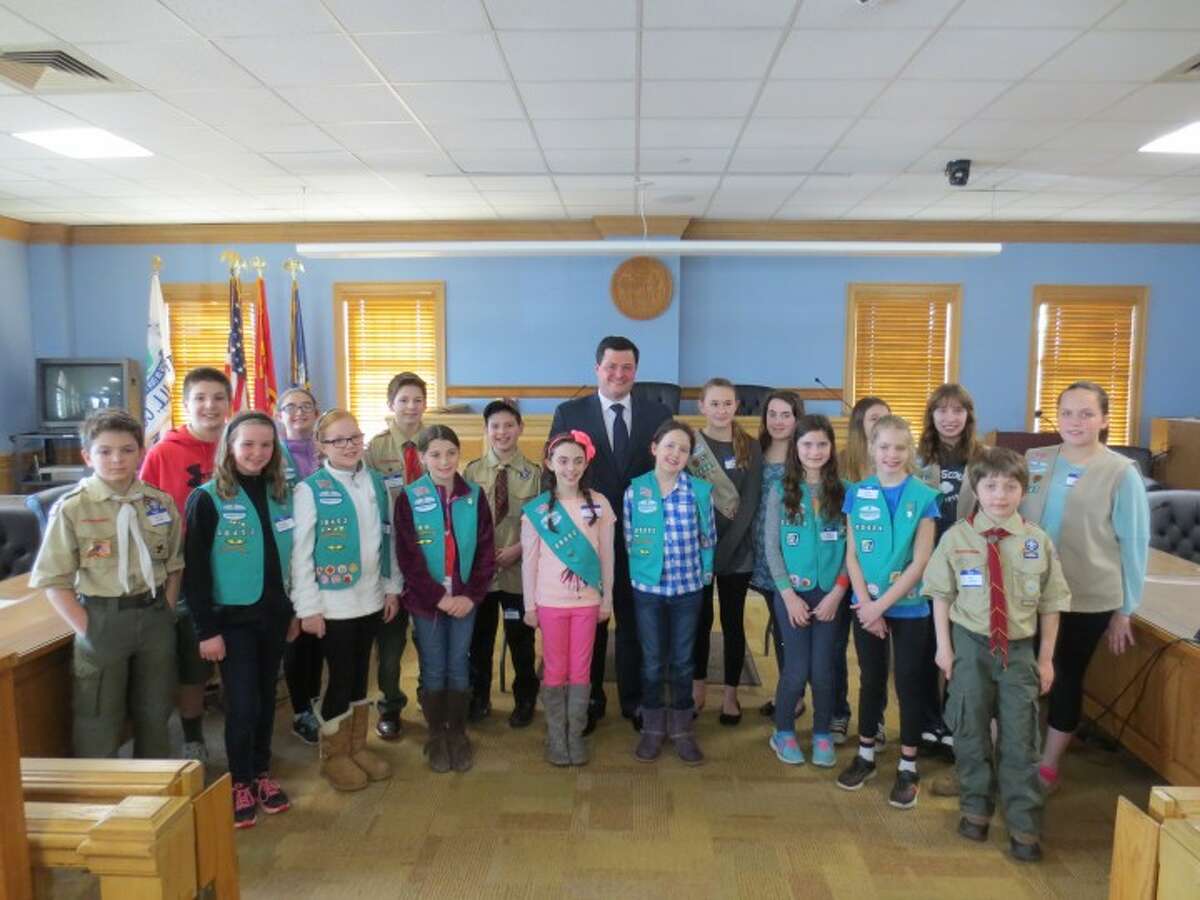 Eighteen Trumbull scouts pose for a photo with First Selectman Tim Herbst at the closing ceremony of Scouts in Government Day, which was held at Town Hall on March 16.