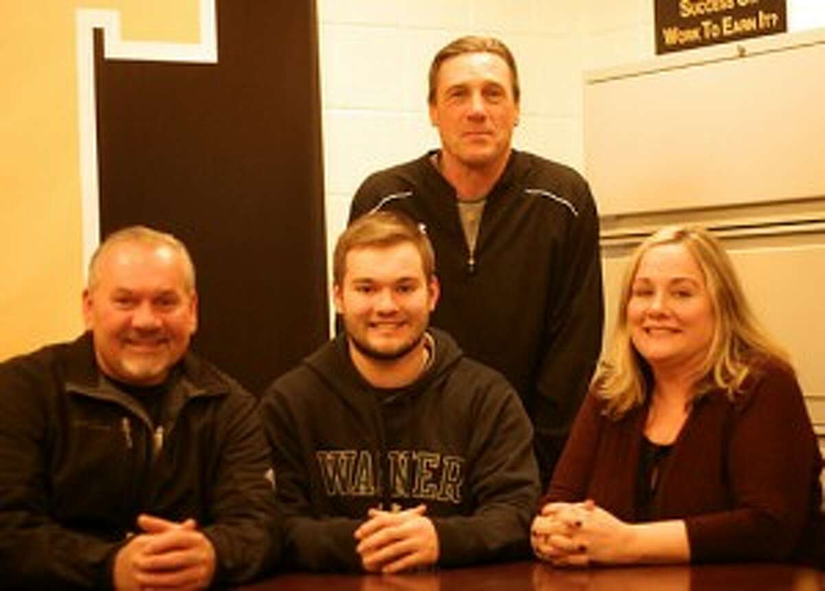 Trumbull High’s Steve Nagy is flanked by dad Eric and mom Jeannie, while Trumbull head coach Bob Maffei stands behind him, while signing to play football for Division I Wagner College. — Bill Bloxsom photo