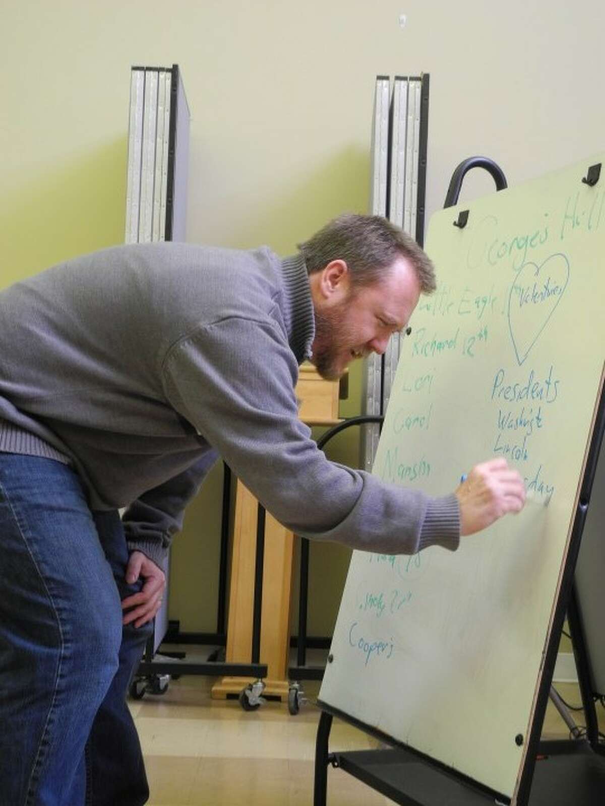 The Rev. Todd Shipley writes down memorable February events on a whiteboard inside Unity Hill United Church of Christ, located at 364 White Plains Road. The church hosts George’s Hill, a social engagement group for persons with memory problems or early dementia and their caregivers, the second Thursday of the month from 11:30 a.m. to 1 p.m. — Steve Coulter photo