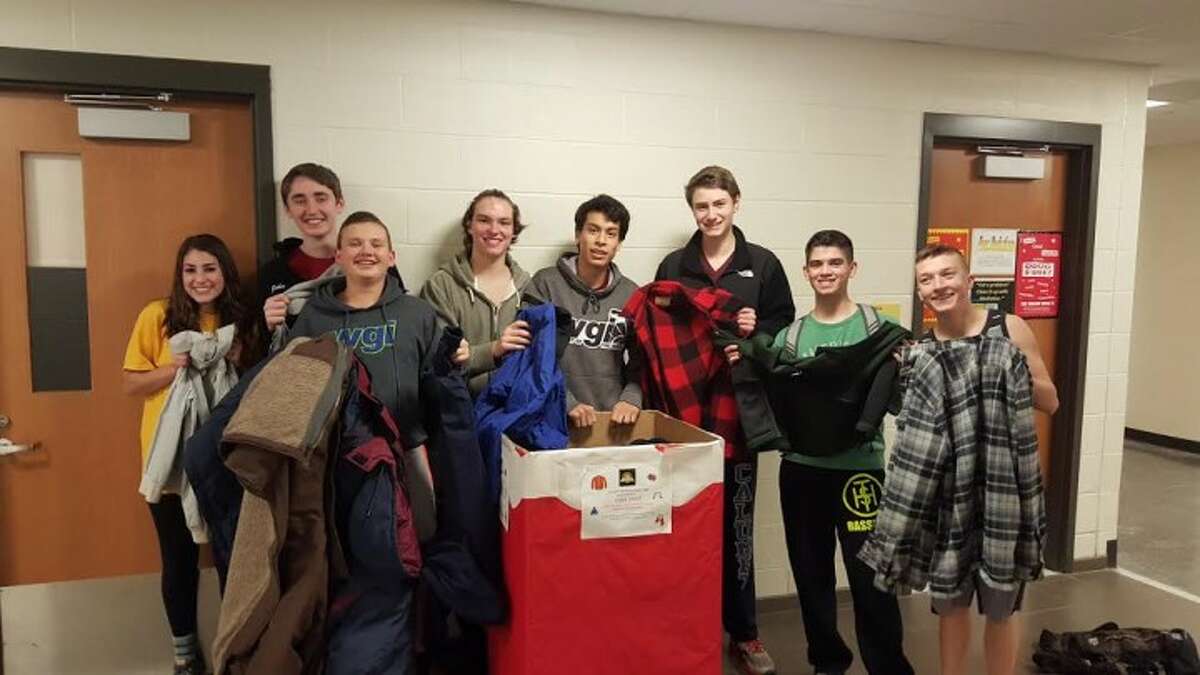 Members of the Trumbull High School Golden Eagle Marching Band display some of the coats they collected this year.