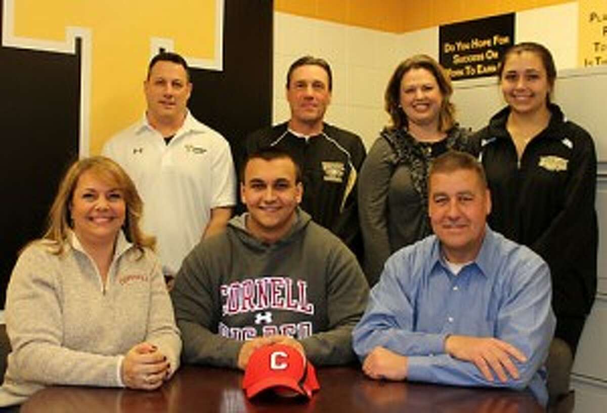 Cory Haslam, with his mom Mary Lou and dad Larry, gathered at Trumbull High to mark his decision to play football at Cornell University. Joining them were Trumbull line coach Bill Pinto, head coach Bob Maffei, faculty advisor Jamie McEnaney and his sister Lauren. — John Kovach photo