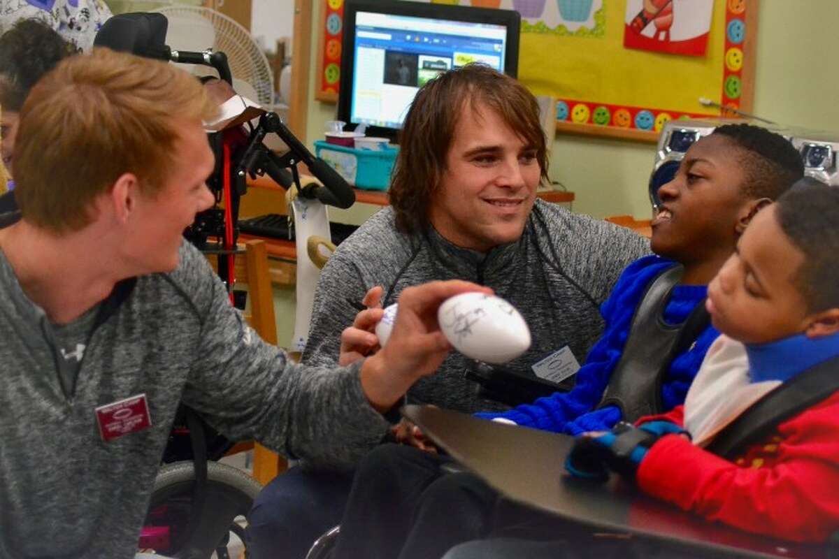 From left to right: Walter Camp All-American Football Team members Daniel Carson, a kicker for Auburn University, and Jamie Silva, a former safety for the Indianapolis Colts, greeted and handed out signed footballs to students at the Feroleto Children's Development Center in Trumbull on Friday, Jan. 15. The players, who were joined by Fairfield University's Stags Mascot, made the special visit to kick off the new year and celebrate the football season. There was plenty of laughter and even some dancing as students received signed footballs from the players. - Lisa Romanchick photo