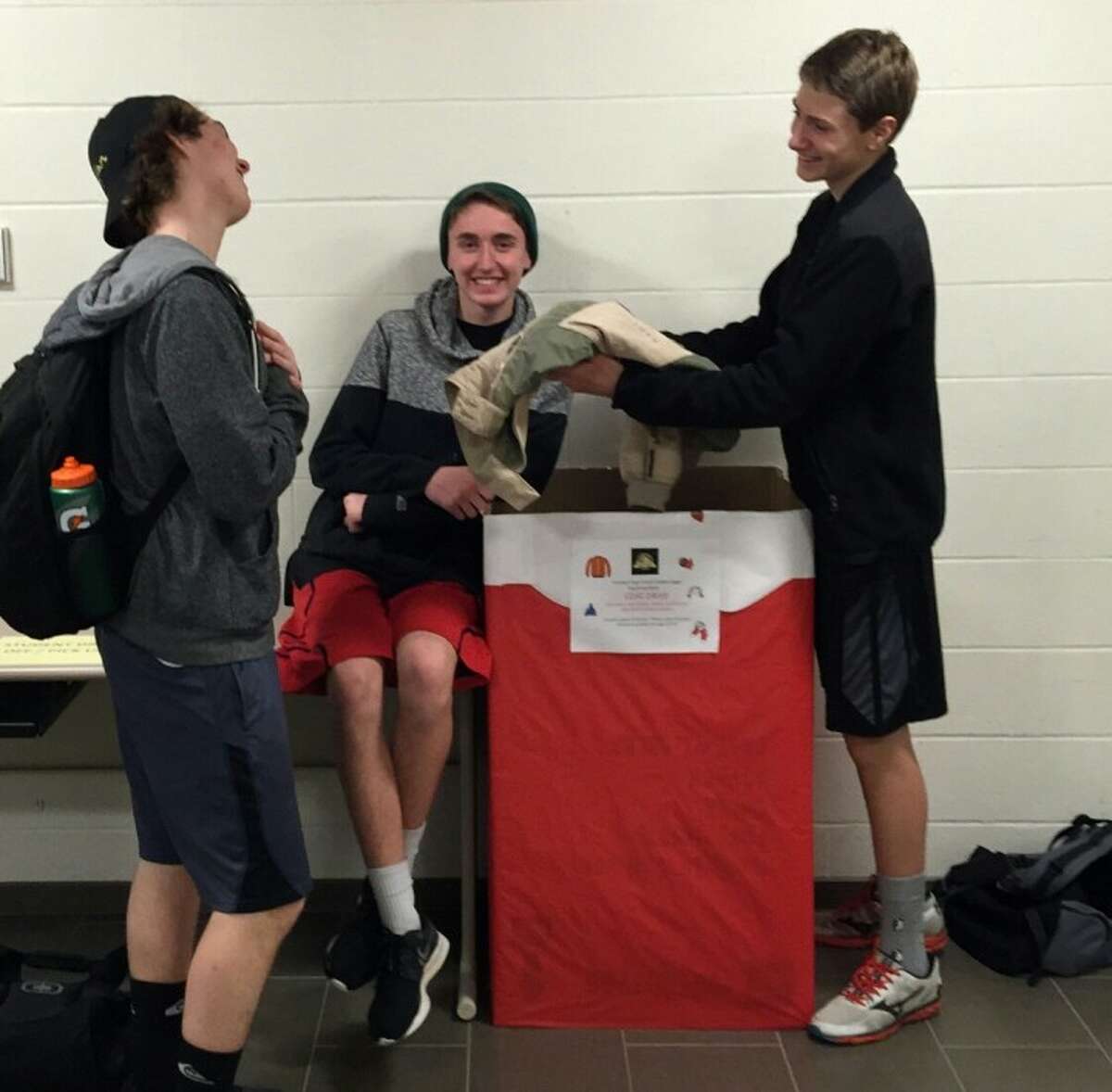 Jack Duda, John Targowski and Josh Merkin collect coats at the high school for the marching band's coat drive that is now running through the month of January.