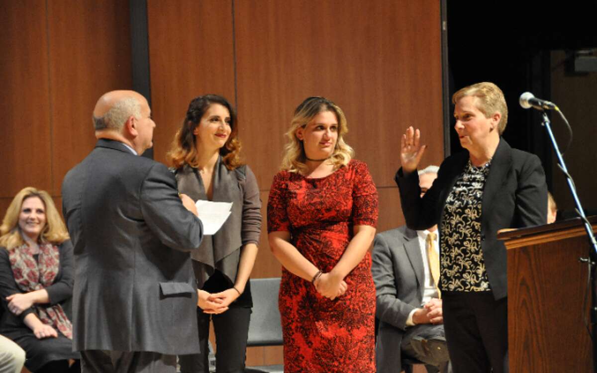 Tom Tesoro administers the oath of office to his wife, First Selectman Vicki Tesoro Monday at Trumbull High School. The two were joined on stage by daughters Melissa and Laura. — Bill Chin photo