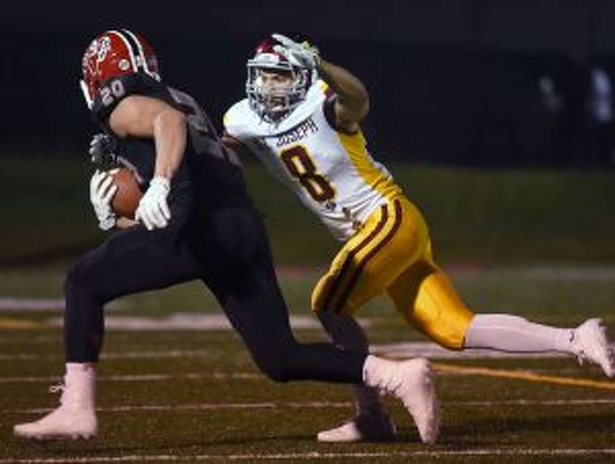 St. Joseph’s Darren Warren (8) looks to bring down New Canaan’s Quintin O’Connell (20) in the season opener. The Rams host Trumbull Friday and the Cadets take on Darien Saturday in key FCIAC clashes. — Dave Stewart photo