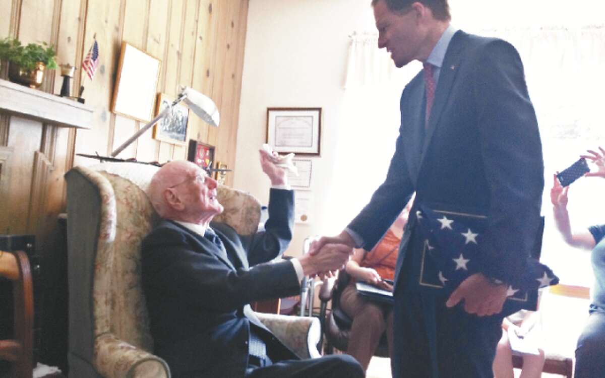 U.S. Sen. Richard Blumenthal presents WWII veteran George Bekech, 94, of Trumbull, with a folded American Flag as a token of thanks for his service and sacrifice. Bekech lost his hearing in the war. — Donald Eng