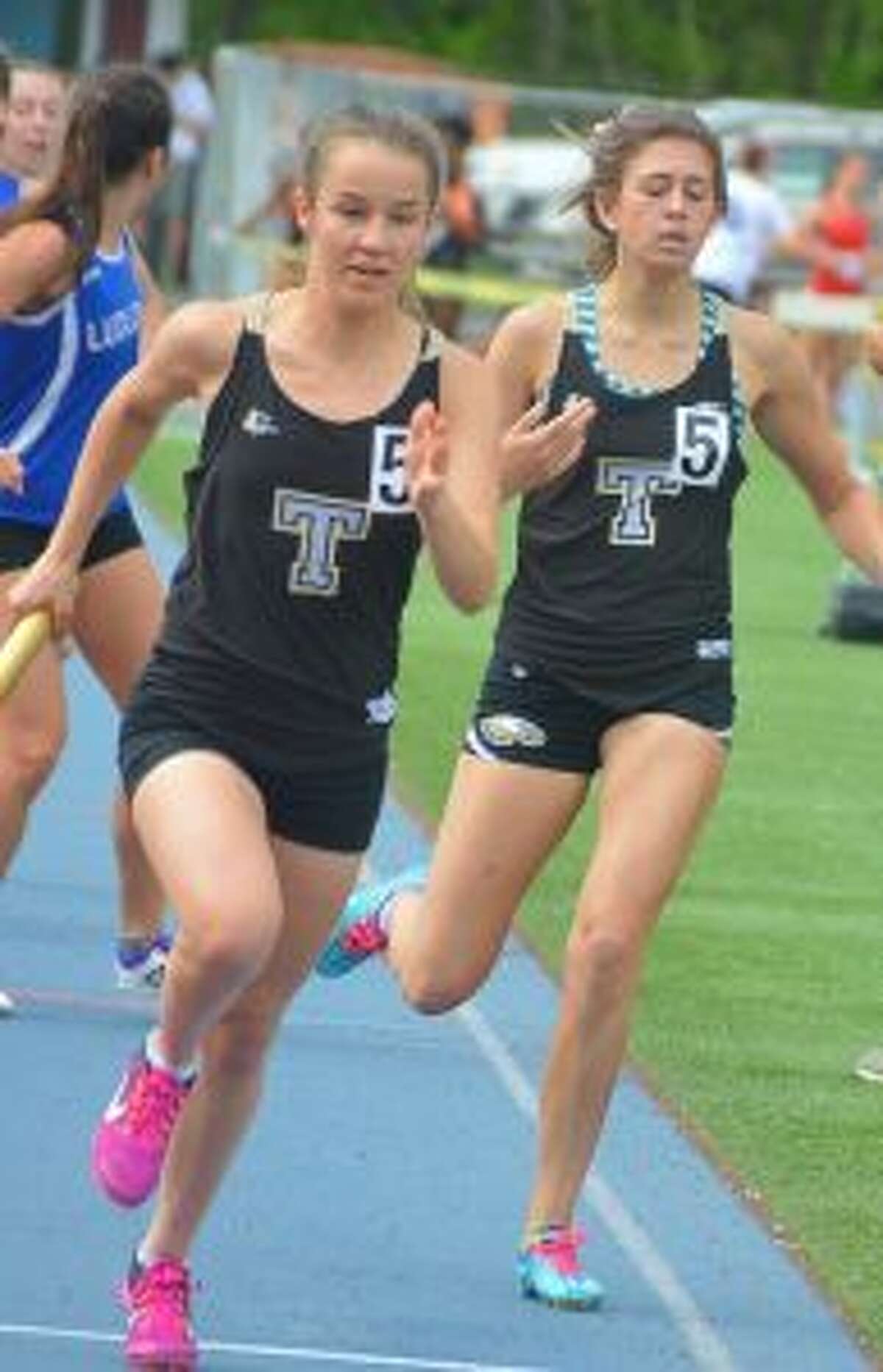 Kate Romanchick takes baton from Ashley Storino for the final leg of the 4x800 meter relay at the FCIAC championships.