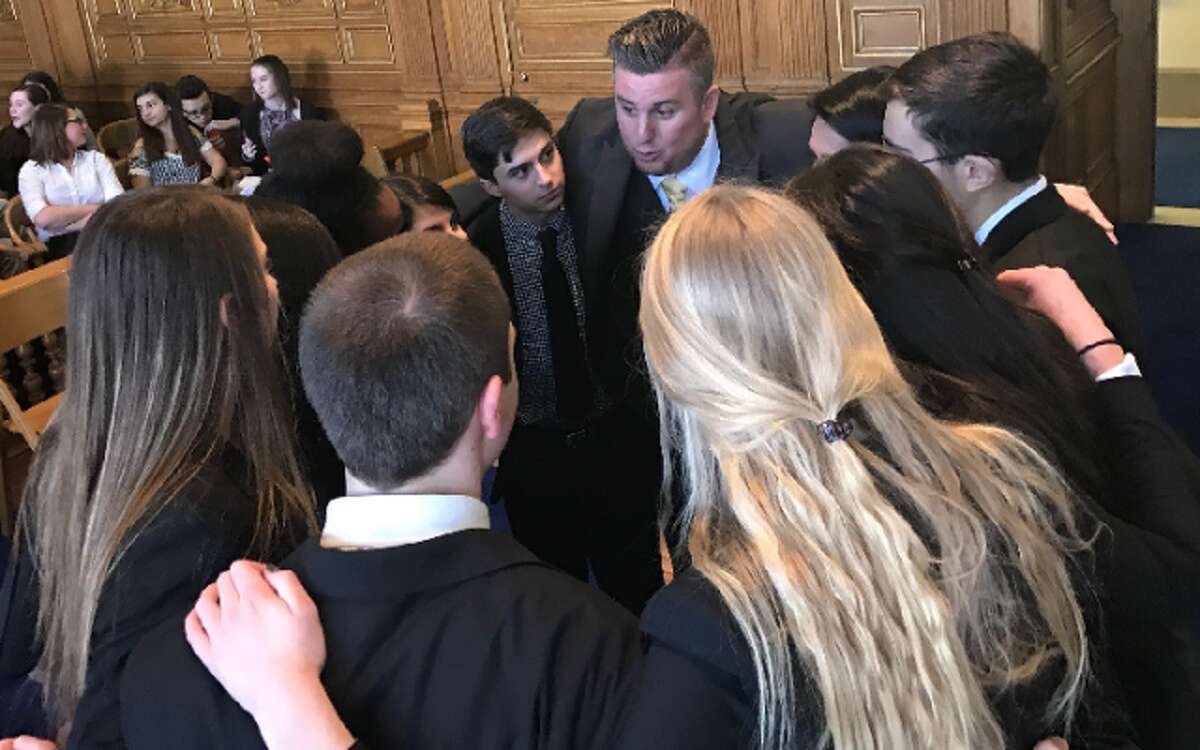 Trumbull High social studies teacher Eric August delivers a pre-trial pep talk to members of the school’s mock trial team. Trumbull recently defeated Ridgefield to win the state championship.