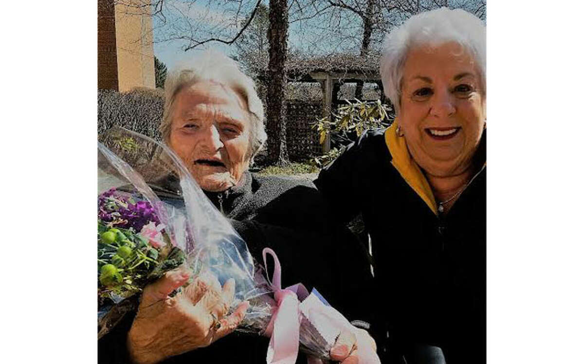 Long Hill Garden Club member Arlene DAgosto brightens the day of a St. Joseph's Manor resident.