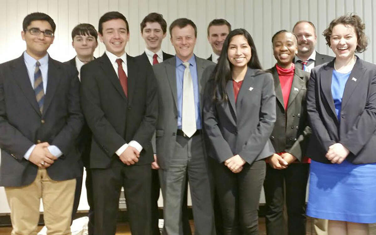 Debaters pose with Debate Moderator T. R. Rowe (fifth from left) and Trumbull Library Director Stefan Lyhne-Nielsen (second from right).