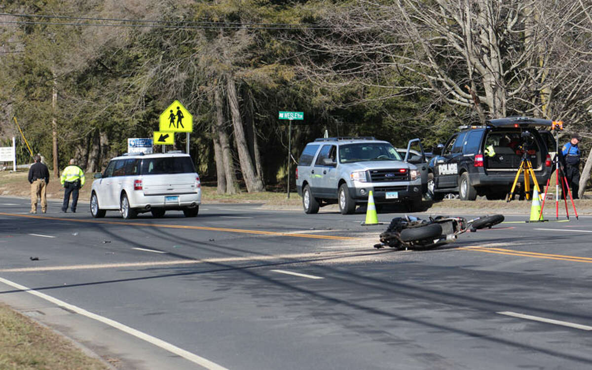 Accident investigators from the Trumbull Police Department document the scene of a crash involving a motorcycle and SUV on White Plains Road near Christian Heritage School Friday, Feb. 24. The school was put into lockdown after reports that a man with a gun fled the scene. A Trumbull man with a valid permit, police said, was taken into custody a short distance from the crash. — John Kovach photo