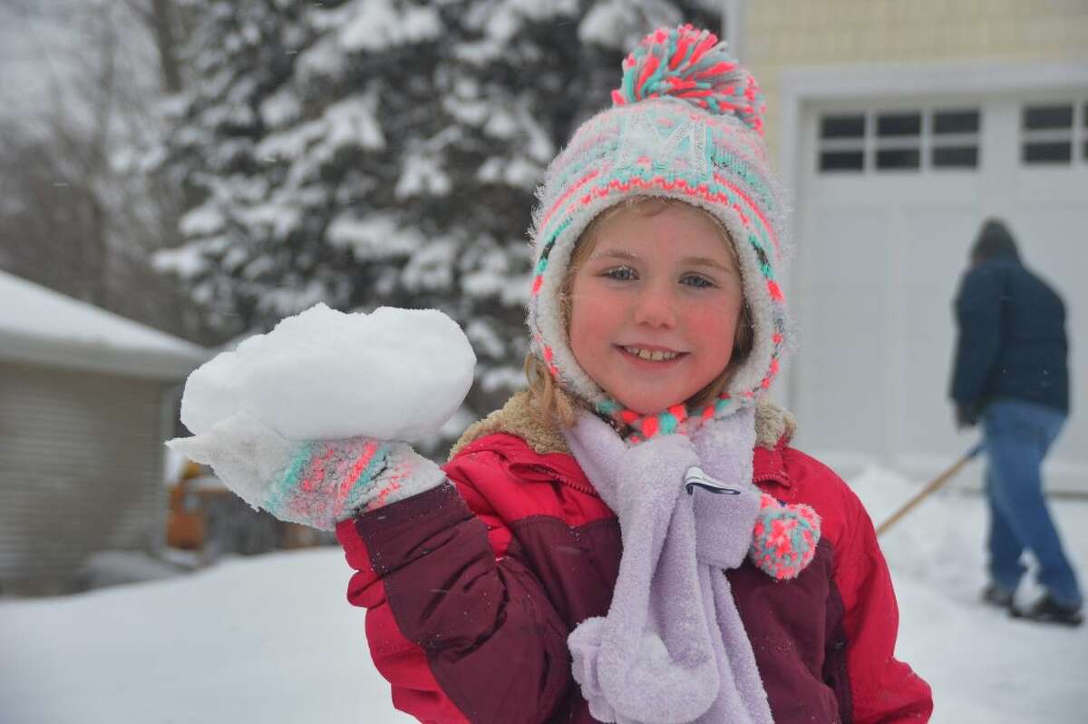 7yr old Maura Brunt helps her Dad clear the driveway in Trumbull