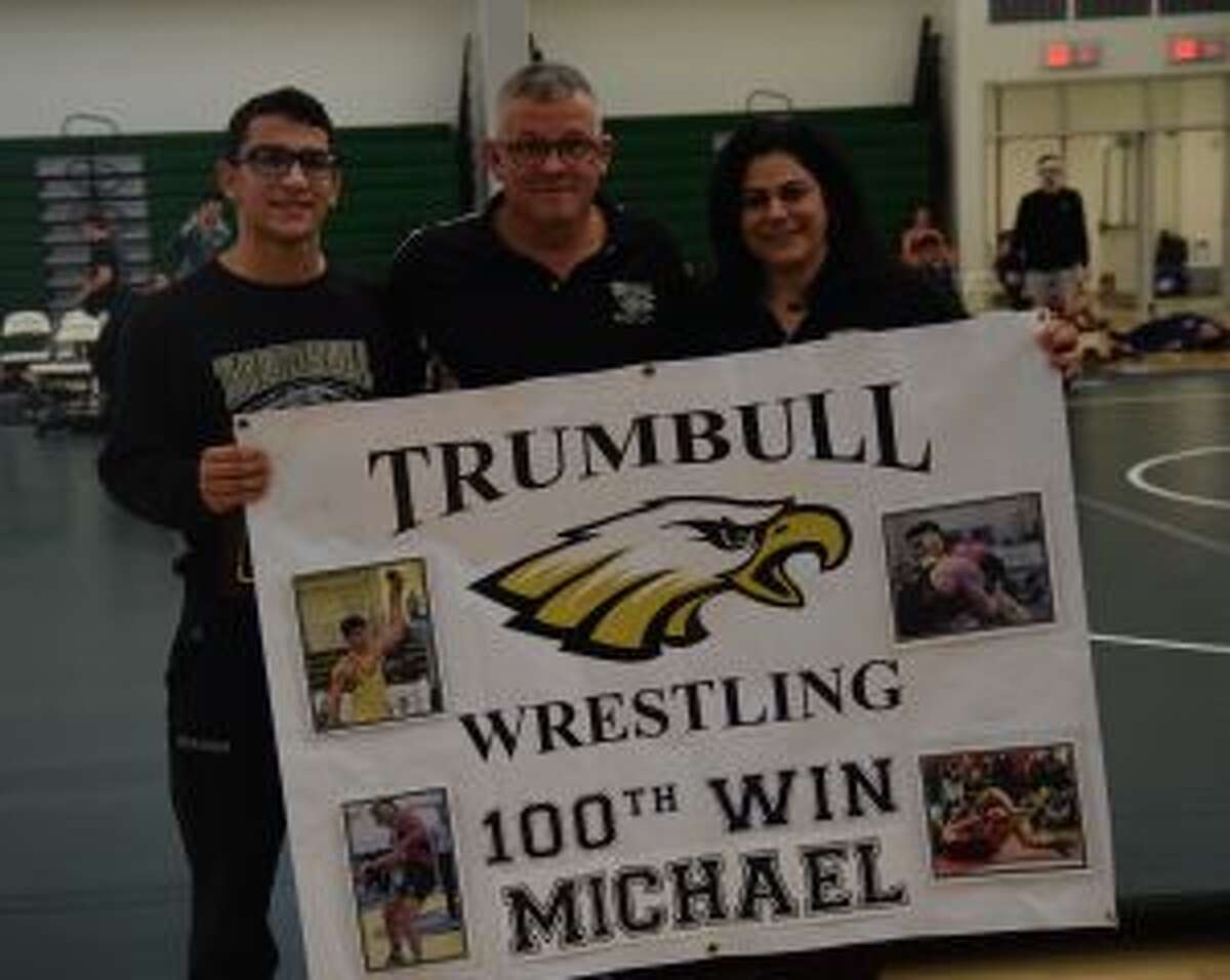 Senior Michael Mirmina celebrates his 100th Trumbull High School varsity wrestling win with Coach Charlie Anderson and his mom Michele Mirmina at the Guilford Duals. — Dee Sollenberger photo