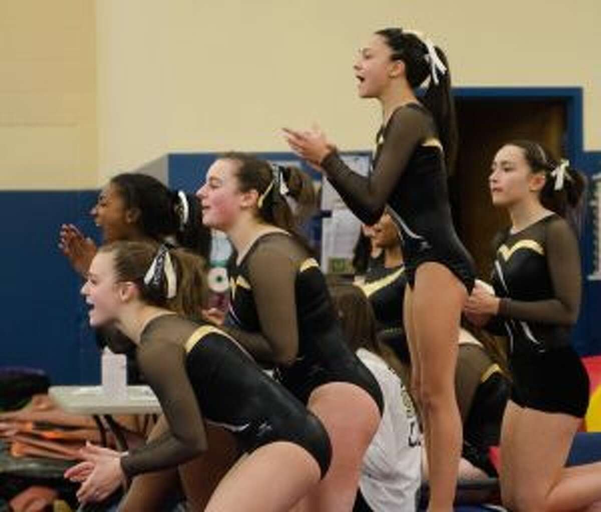 Trumbull High’s Kate Burns, Chantal Boyd, Natalie Smerling, Ashleigh Johnson and Leah Karlan cheer on teammates in a tri-meet on Saturday.