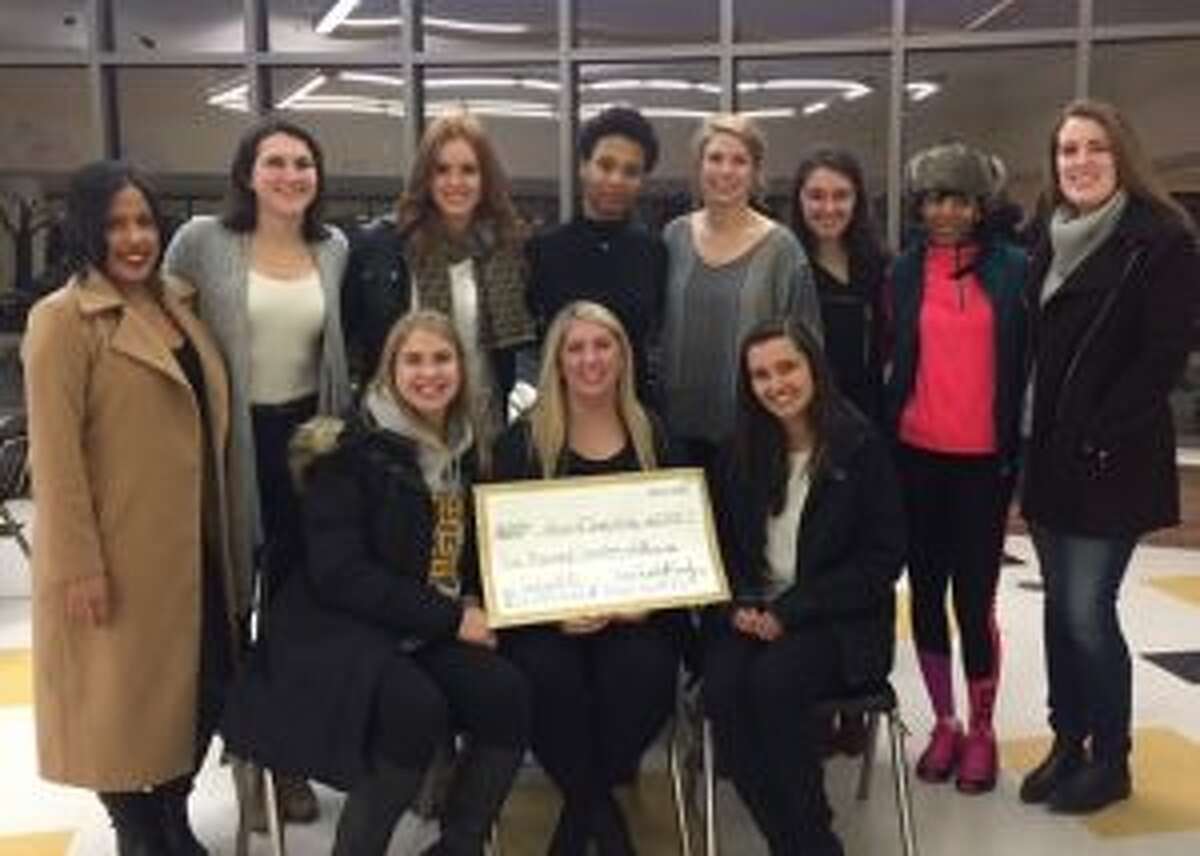 Members of the 2011 FCIAC championship team gather around teammate Allison Kirby, after she was presented with a check from Go Fund Me. Seated are Alexa Pfohl, Allison Kirby and Erin Puglia. Standing are Jackie Palmer, Kelly Coughlin, Kelly Metzger, Taisha Lima, Victoria Pfohl, Meg Puglia, Chontayvia Kennedy and Erin Moore.