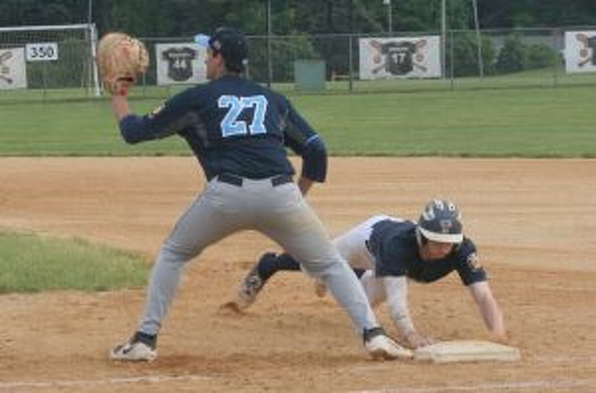 Trumbull's Jack Lynch, who had four hits, dives back into first base safely.