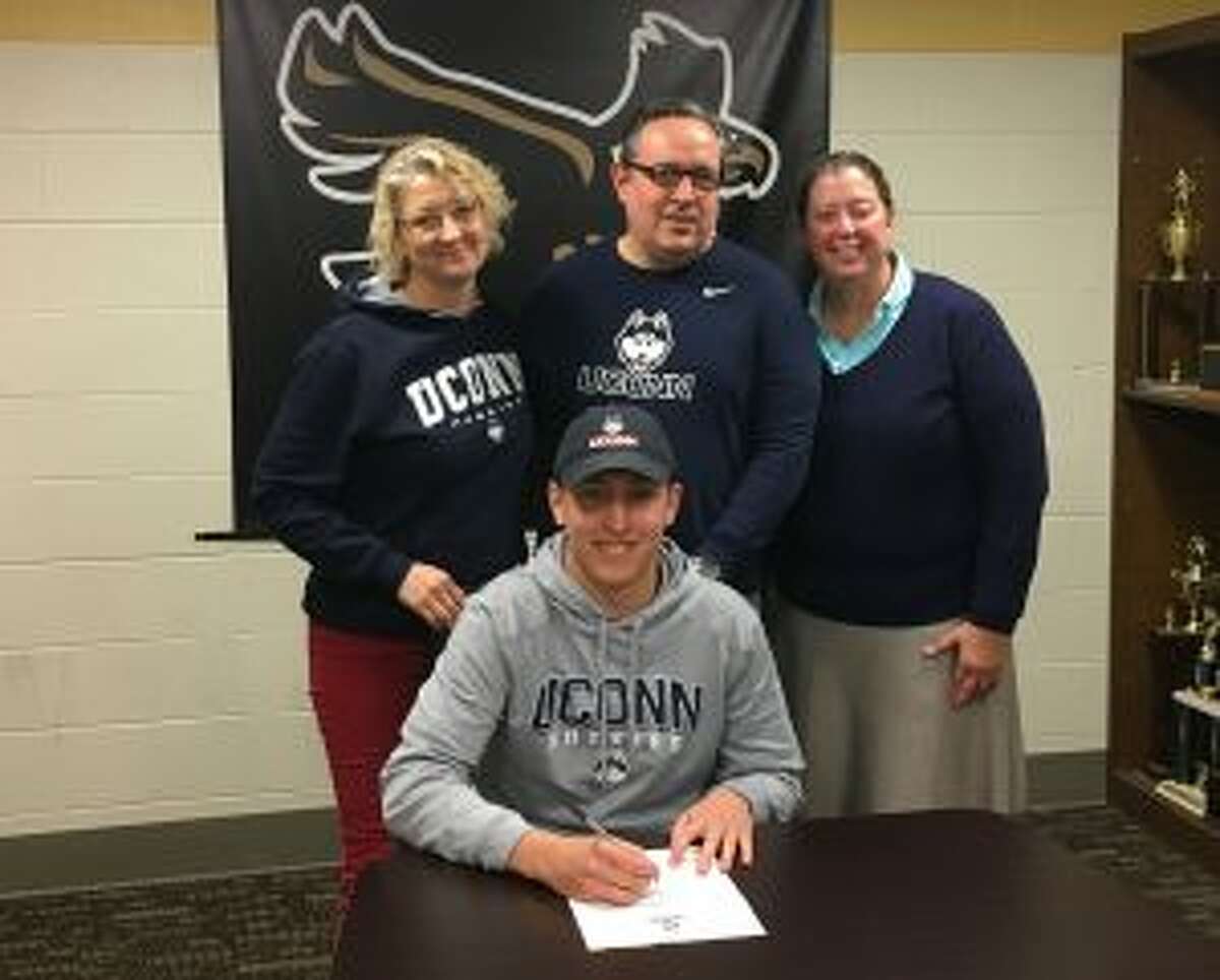 Jack Gray puts pen to paper after choosing to swim at the University of Connecticut. Backing the Trumbull High senior are mom Claudia Gray, dad Roy and coach Ellen Johnston.
