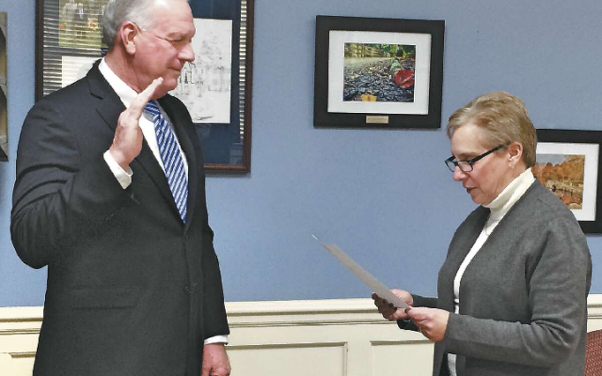 New Police Commissioner Ray Baldwin is sworn into the commission by First Selectman Vicki Tesoro.