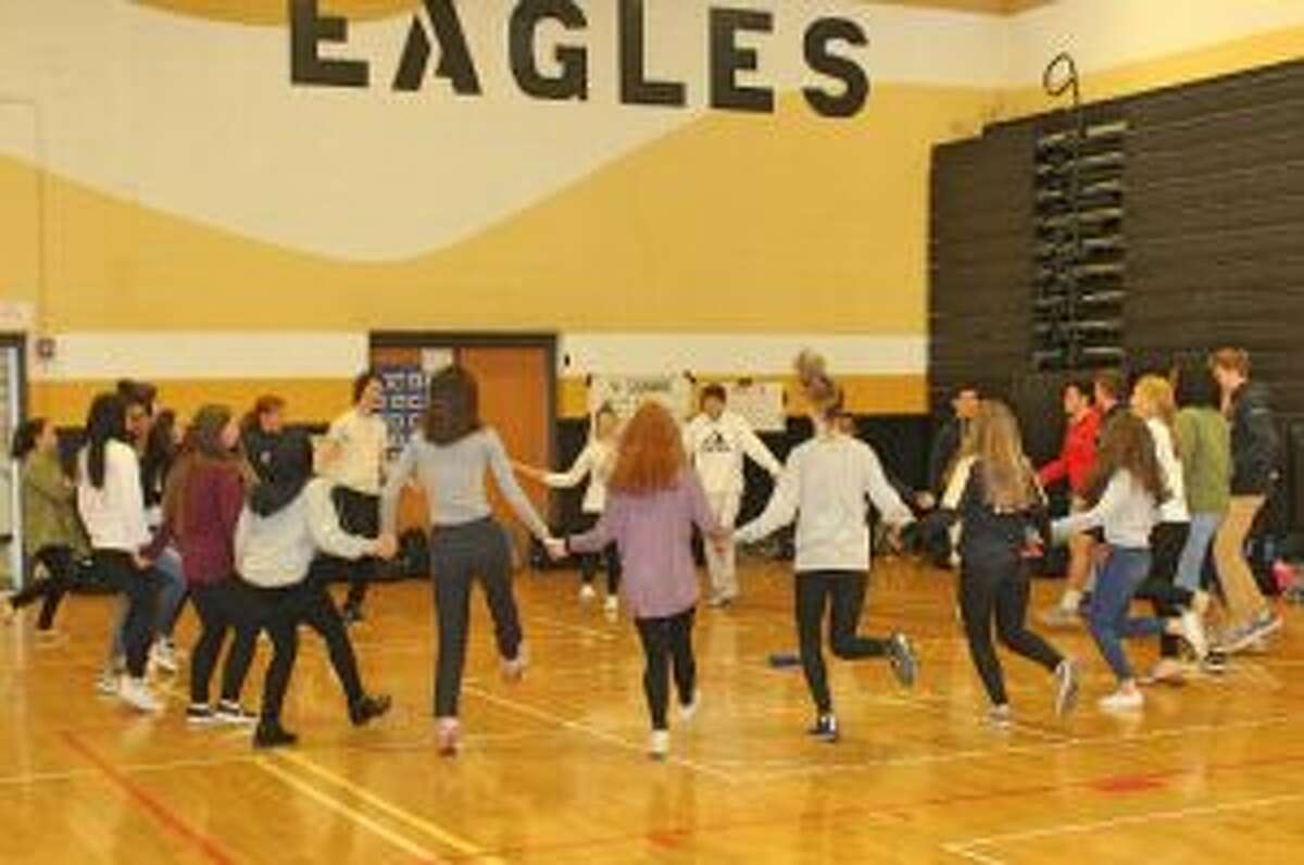 Students at Trumbull High School learn a traditional hora dance during World Language Week at the school.- Matt Nusom