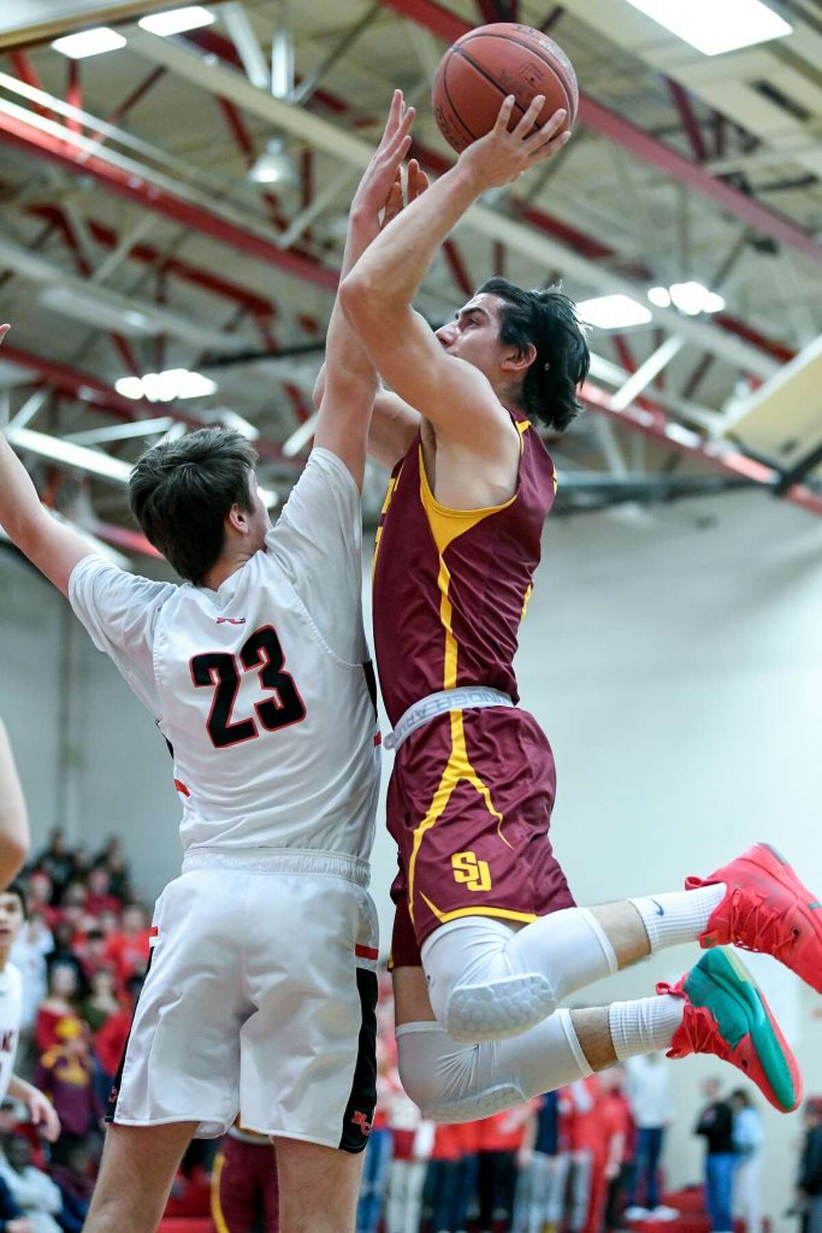 Stephen Paolini shoots a jumper over New Canaan's Jack Richardson.Photo: David G. Whitham / For Hearst Connecticut Media