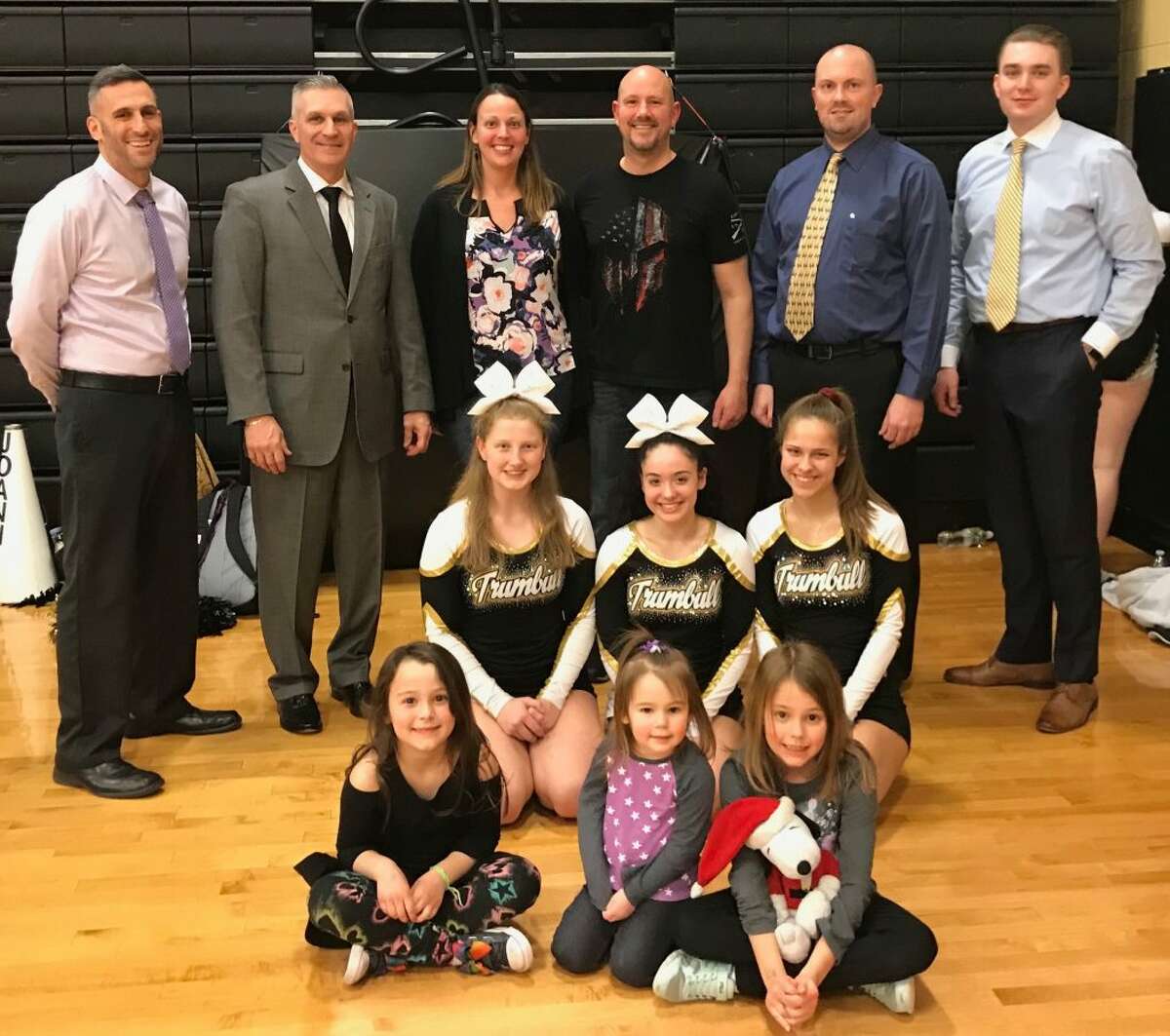 Kief Doyle was honored by the Trumbull High boys basketball program for his military service to our country. Pictured (front row) are daughters Brooklyn Doyle, Cassidy Doyle and Addison Doyle; (second row) THS cheerleaders Katelyn Miller, Joanna Vizcarrondo and Ashley Deal; (third row) Trumbull assistant coach Matt Landin, head coach Buddy Bray, wife Rachel Doyle, Keif Doyle, assistant coach Bob Packer and assistant coach Cliff Bray.