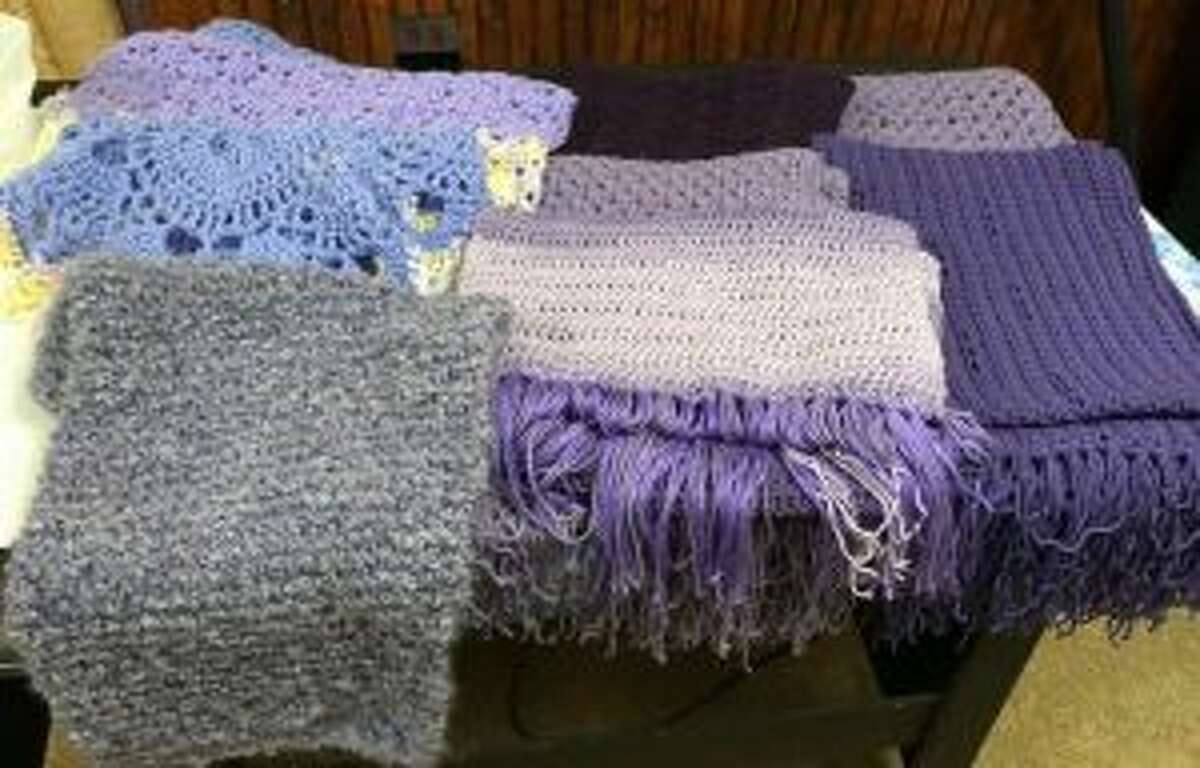 These shawls in purple, knit or crochet, will go to a victim of domestic violence.