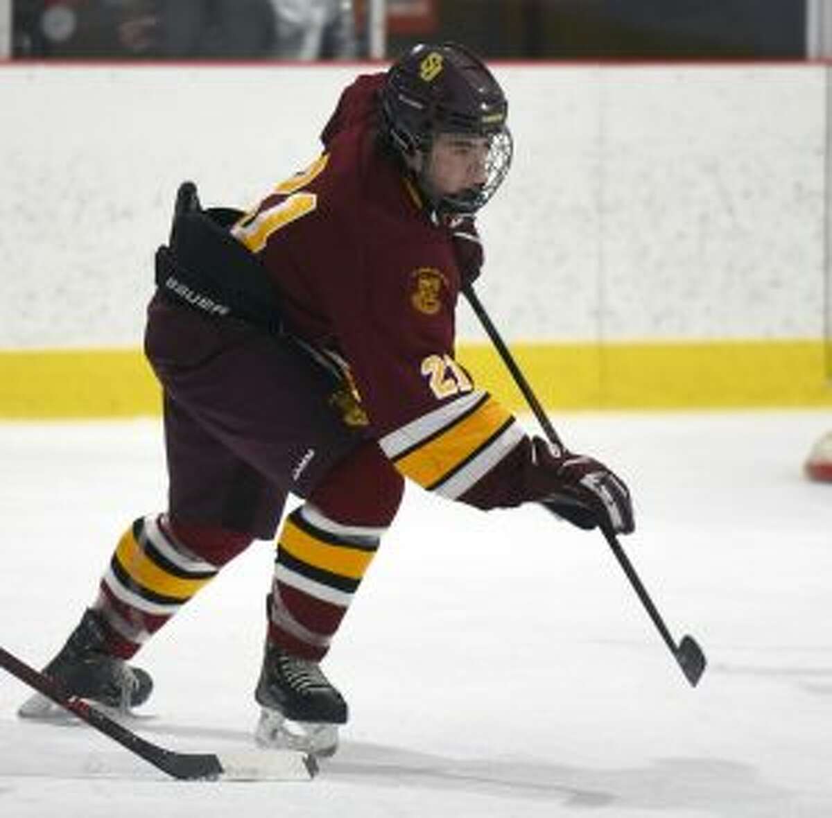 St. Joseph’s Charlie Chagnon (21) clears the puck.— Dave Stewart/Hearst Connecticut Media photo